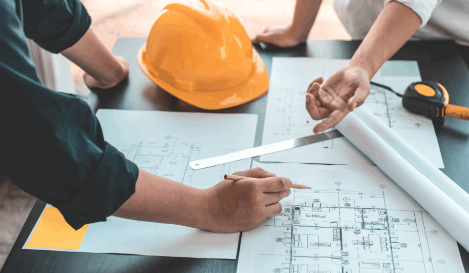 Engineers reviewing building design plans to ensure compliance with ASHRAE Standards for indoor air quality and safety.
