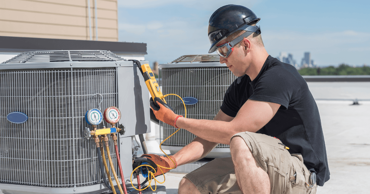 HVAC technician servicing rooftop commercial HVAC system to improve indoor air quality and system performance